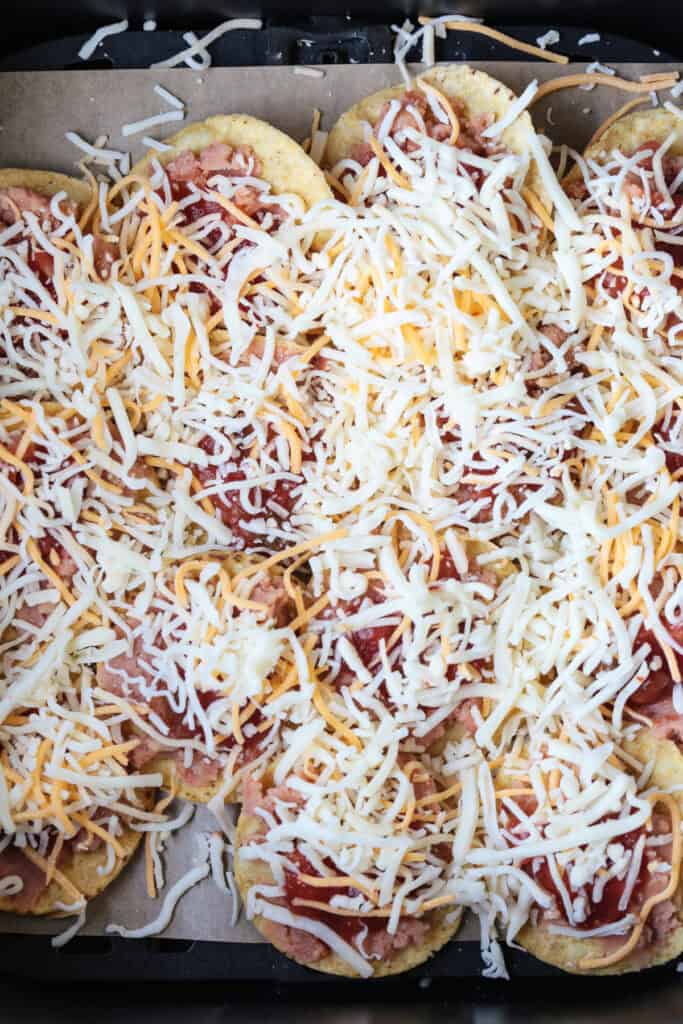 Air Fryer Nachos are so easy to make your kids can do it on their own. Ready in just 5 minutes for after school snacks, appetizers or dinner! chips in air fryer and topped with cheese