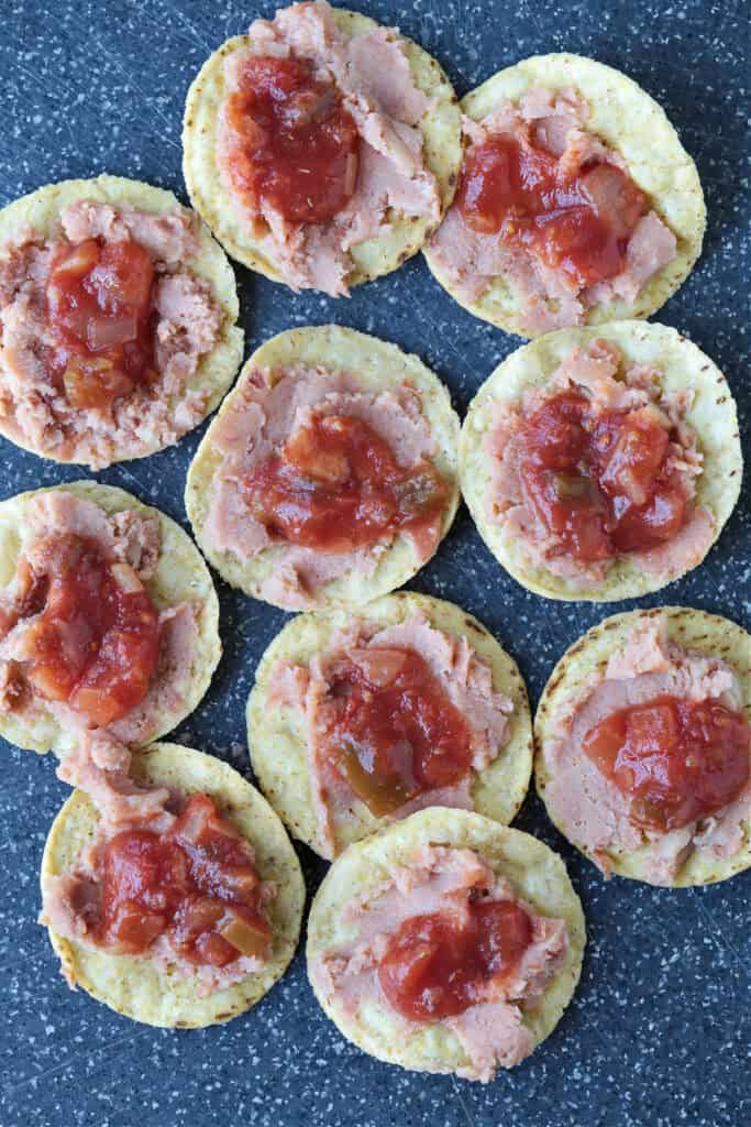 Air Fryer Nachos are so easy to make your kids can do it on their own. Ready in just 5 minutes for after school snacks, appetizers or dinner! salsa and refried beans on tortilla chips