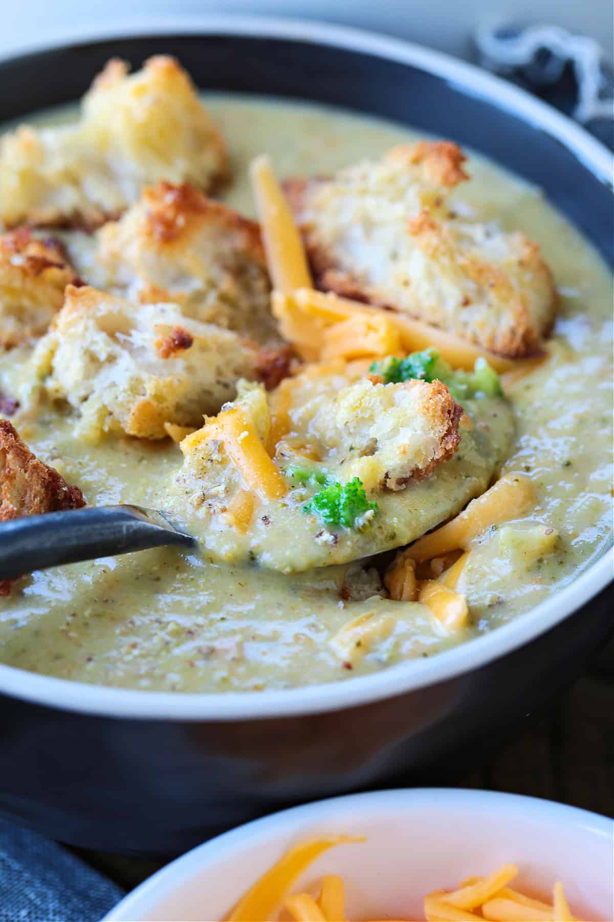 broccoli cheese soup with croutons in a bowl with spoon