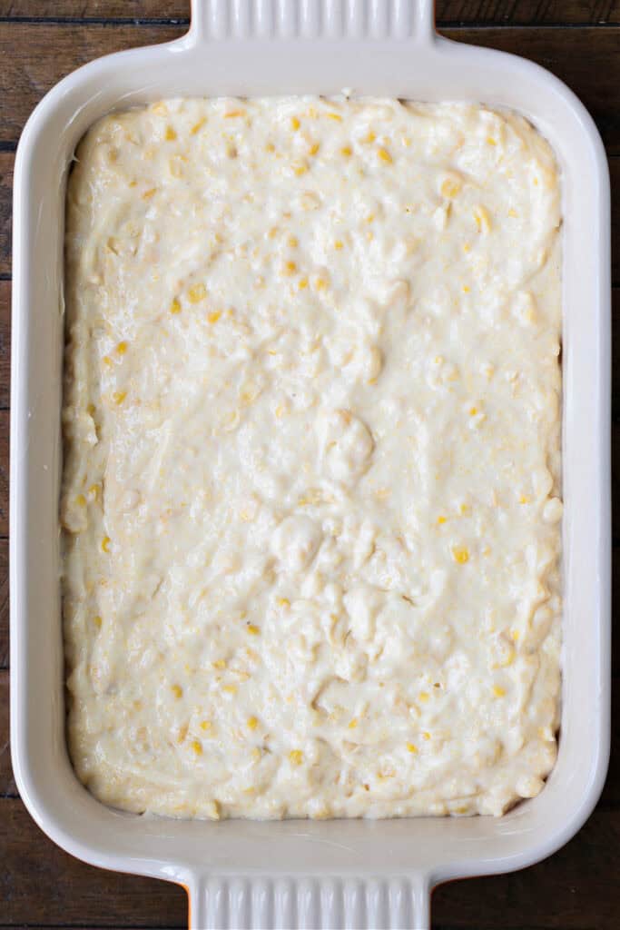 This creamy and sweet Corn Souffle is an delicious side dish for every occasion! Just 5 minutes of prep time and it's ready for the oven! casserole dish with corn souffle batter ready for baking