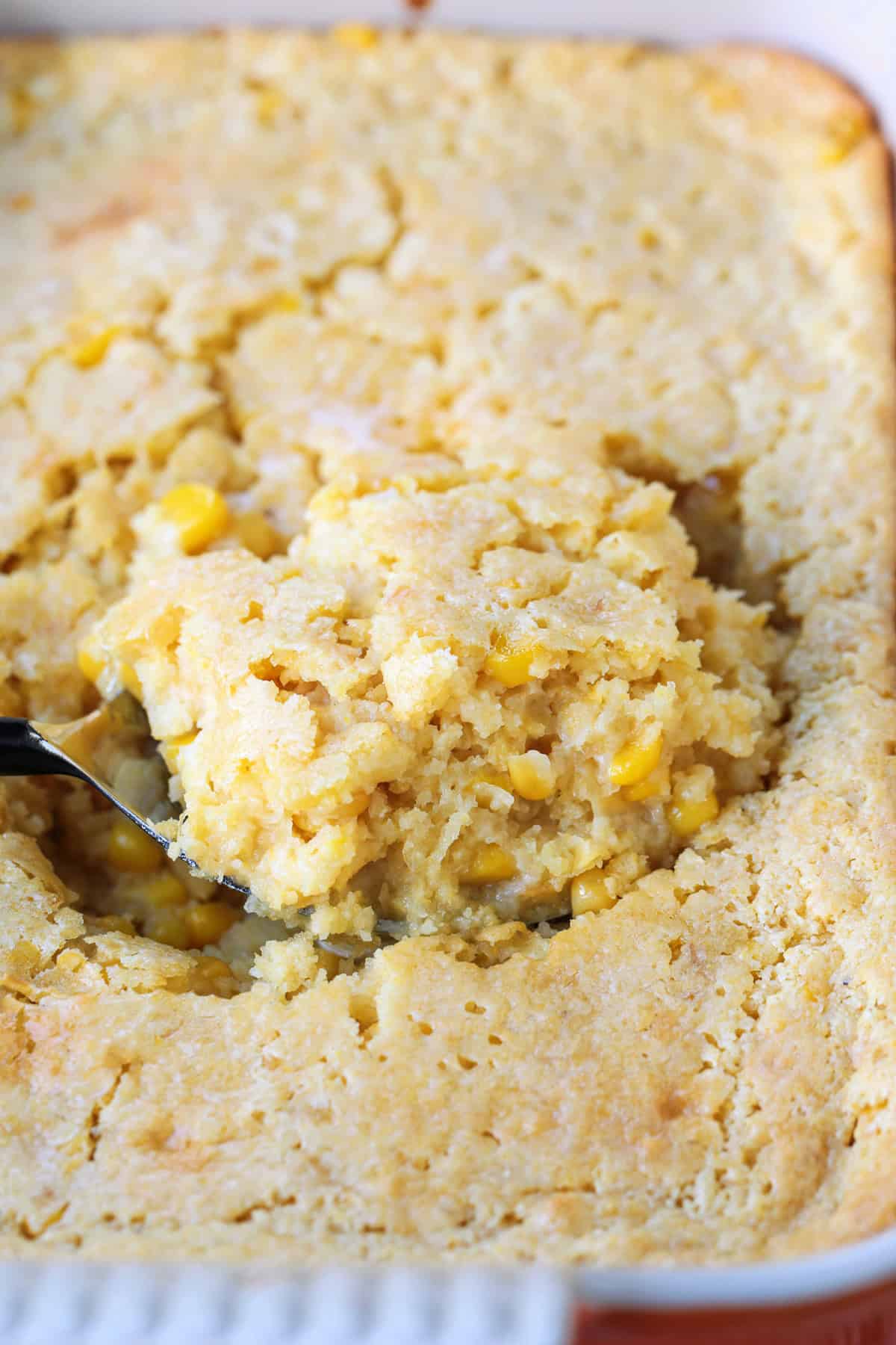 This creamy and sweet Corn Souffle is an delicious side dish for every occasion! Just 5 minutes of prep time and it's ready for the oven! spoon scooping into corn casserole