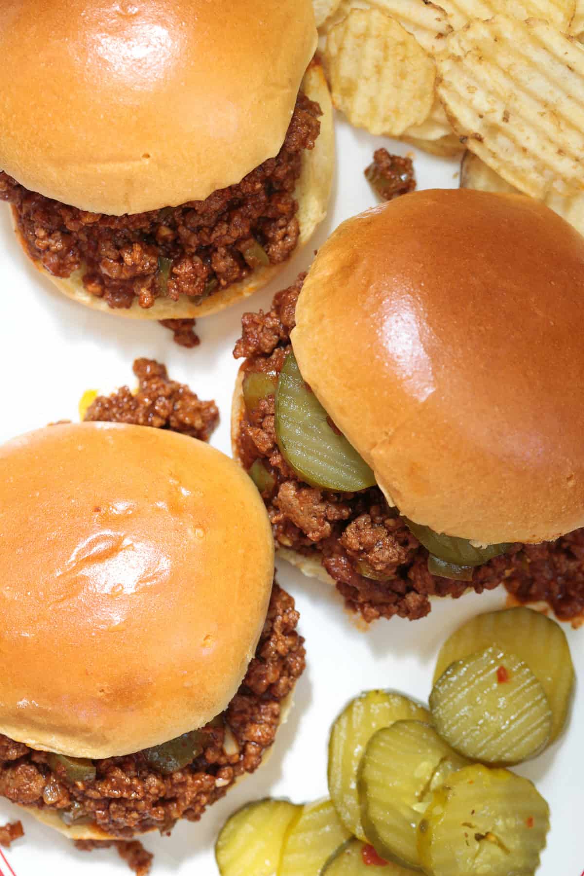 The best Homemade Sloppy Joes! Ground beef in a sweet and tangy sauce with green pepper and sweet onion. Ready in less than 30 minutes! sloppy joe sandwiches on a platter with pickles