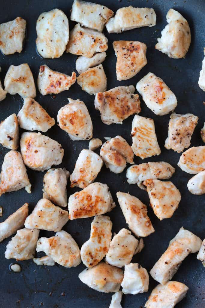 This Almond Chicken recipe is so easy to make and so delicious! Tossed with out homemade 5 minute stir fry sauce, it's better than take out! diced chicken in a skillet