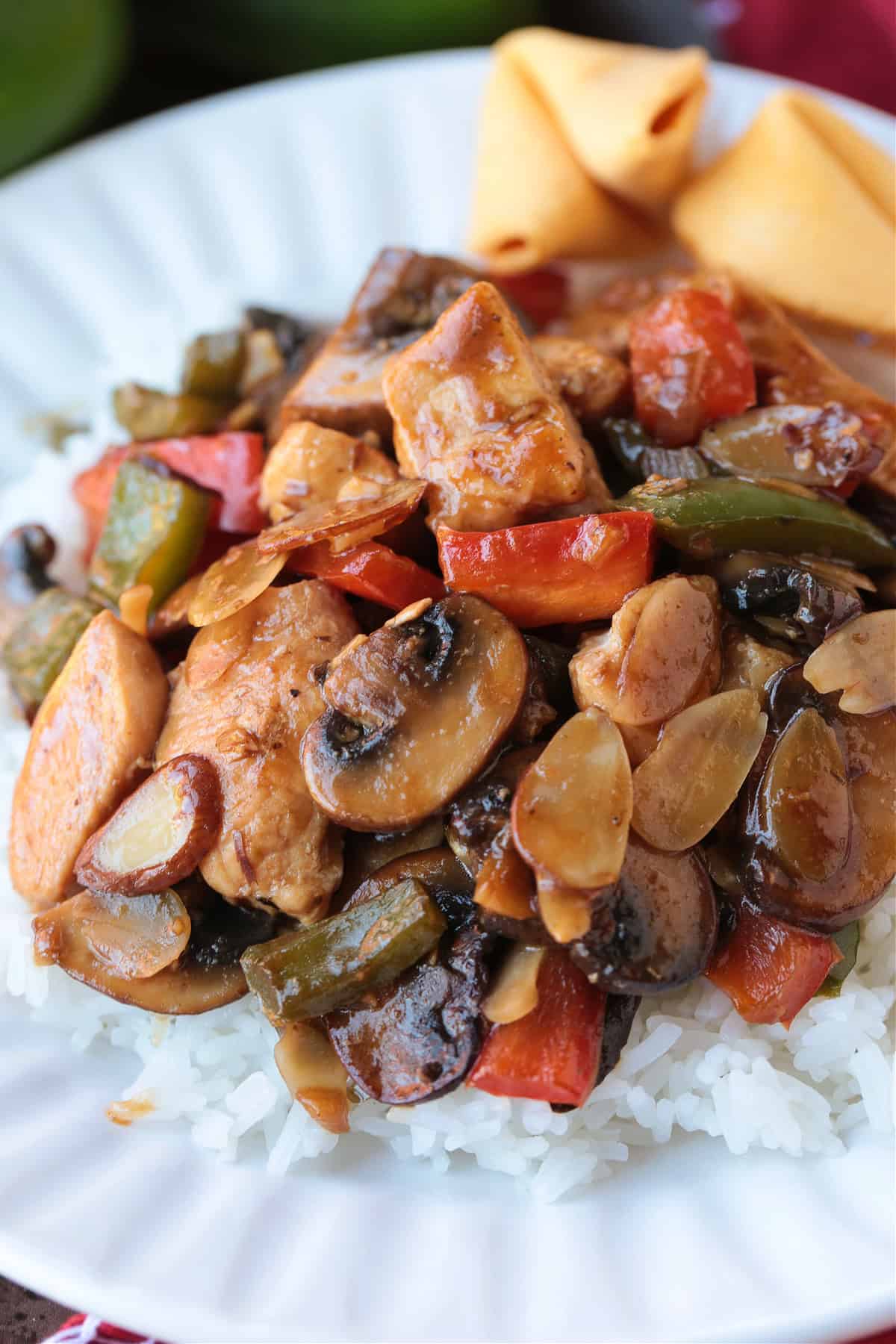 This Almond Chicken recipe is so easy to make and so delicious! Tossed with out homemade 5 minute stir fry sauce, it's better than take out! chicken stir fry on a plate with fortune cookies