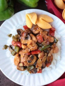 chicken stir fry with mushrooms, peppers and almonds on white plate