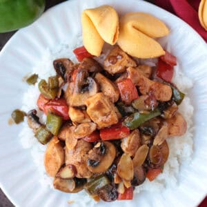 chicken stir fry with mushrooms, peppers and almonds on white plate