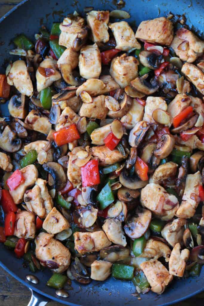This Almond Chicken recipe is so easy to make and so delicious! Tossed with out homemade 5 minute stir fry sauce, it's better than take out! almond chicken stir fry in a skillet