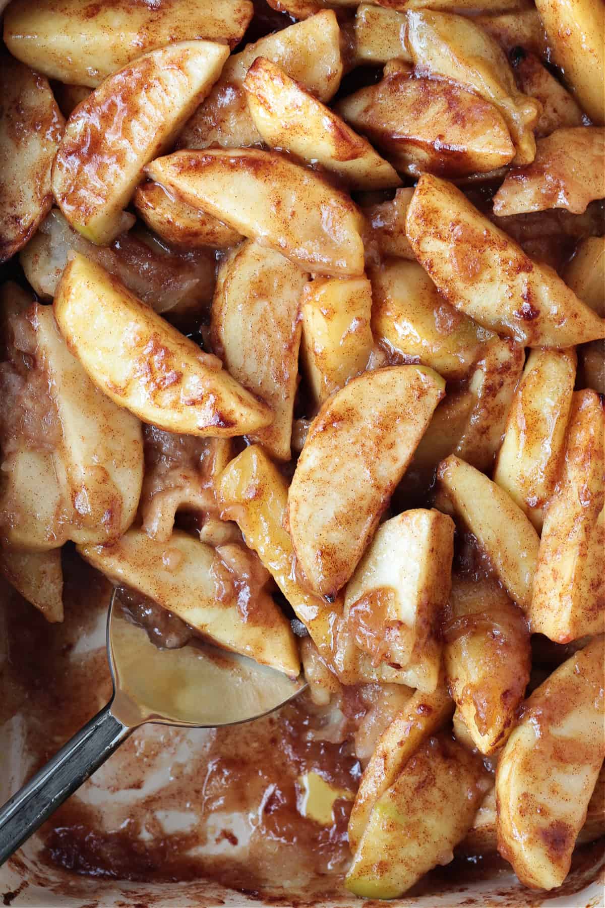 An easy, but dazzling dessert! Baked Sliced Apples are so delicious spooned over ice cream or served with whipped cream on the side. baked apple slices with serving spoon