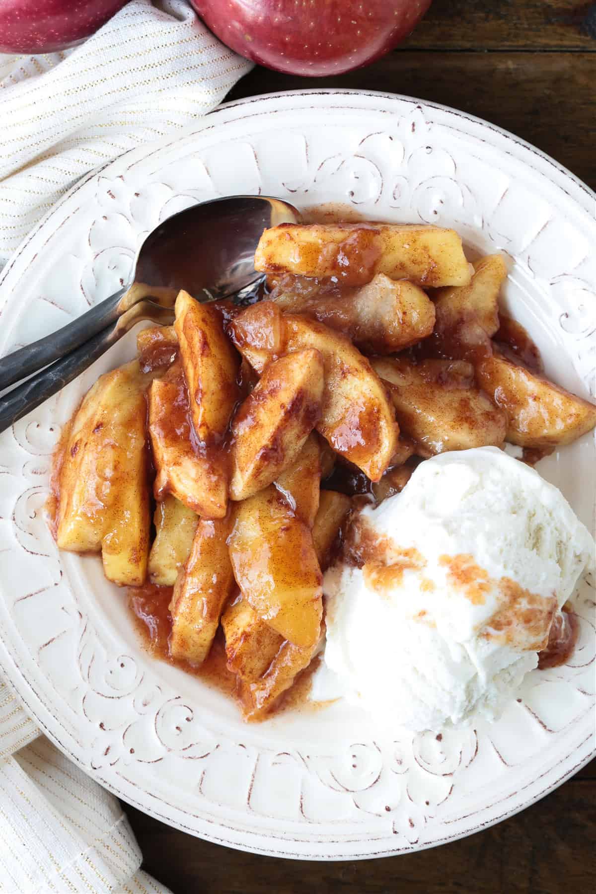 An easy, but dazzling dessert! Baked Sliced Apples are so delicious spooned over ice cream or served with whipped cream on the side. apples with brown sugar and cinnamon on plate with ice cream