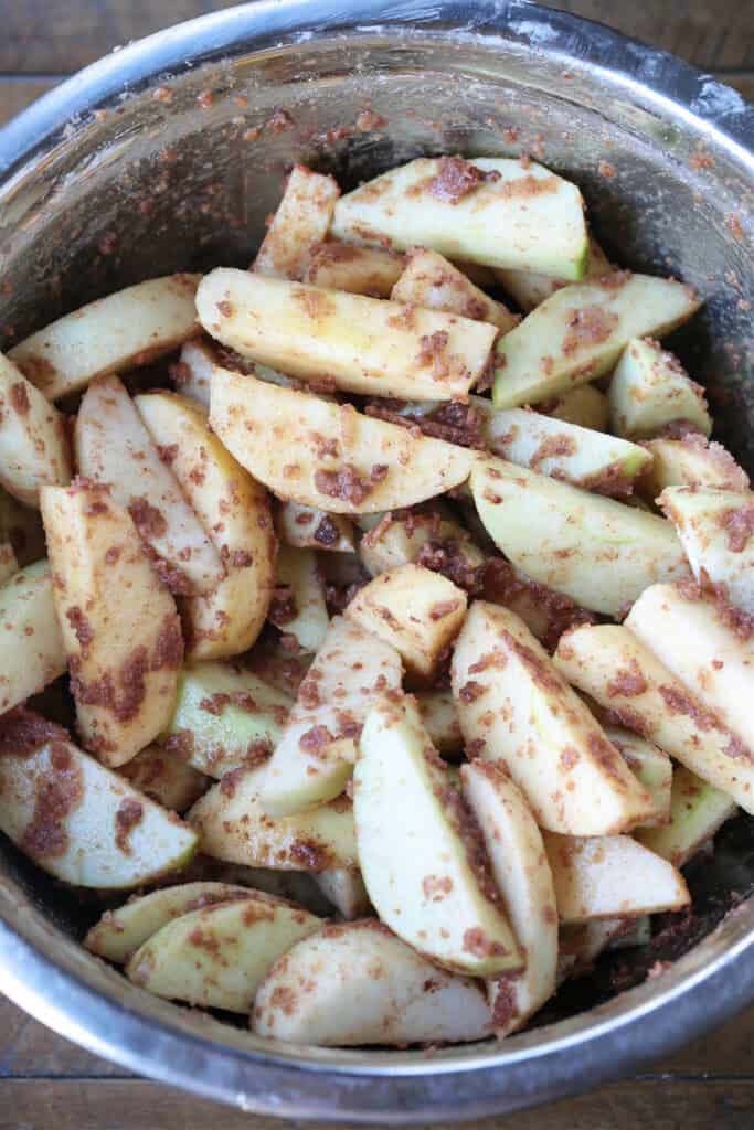 An easy, but dazzling dessert! Baked Sliced Apples are so delicious spooned over ice cream or served with whipped cream on the side. sliced apples tossed in a bowl with brown sugar and cinnamon