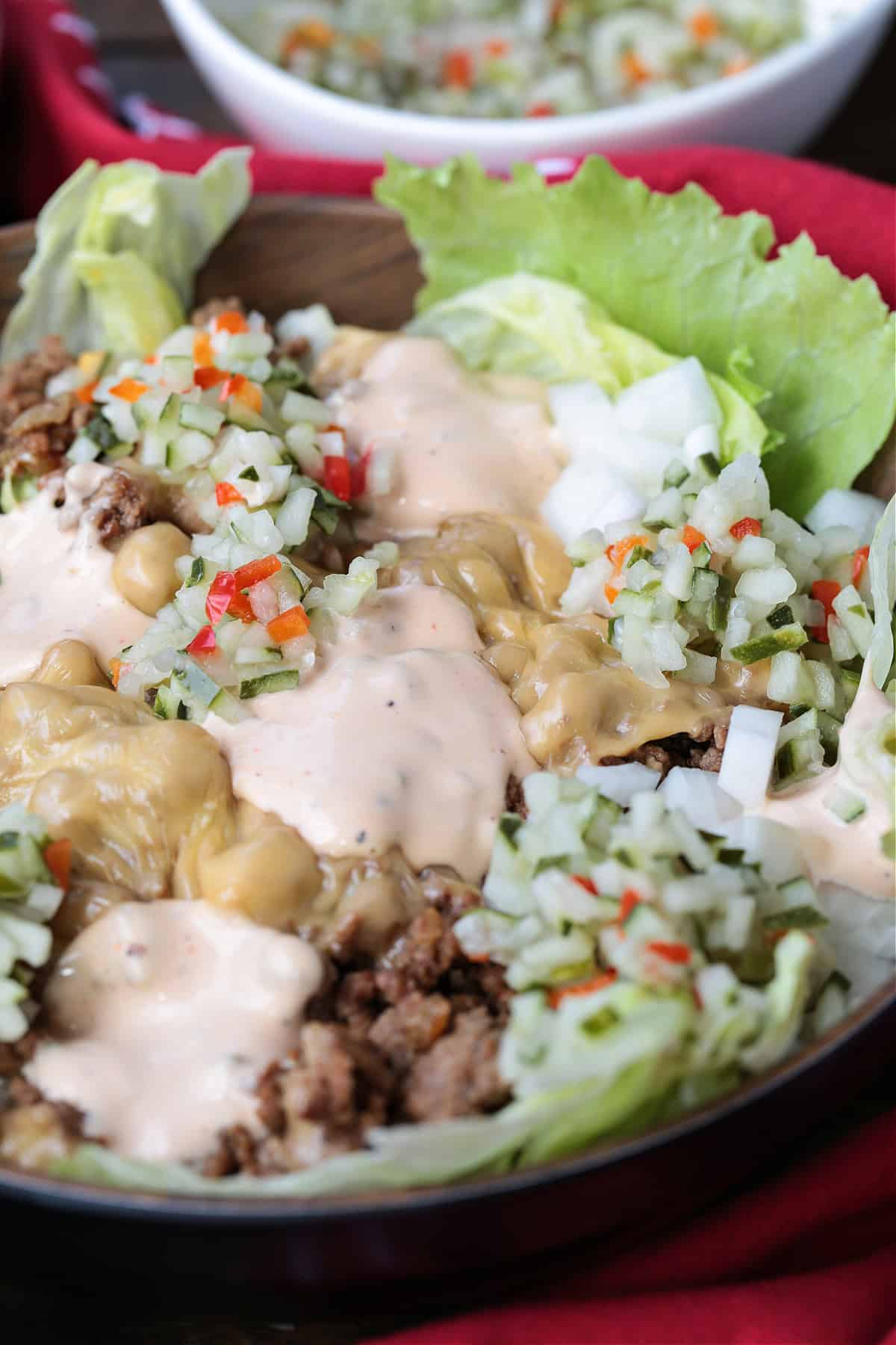 Make a Cheeseburger Bowl for parties, game days or just a fun dinner! All the flavors of your favorite cheeseburger drizzled with mac sauce! cheeseburger bowl with creamy sauce and pickle relish on top