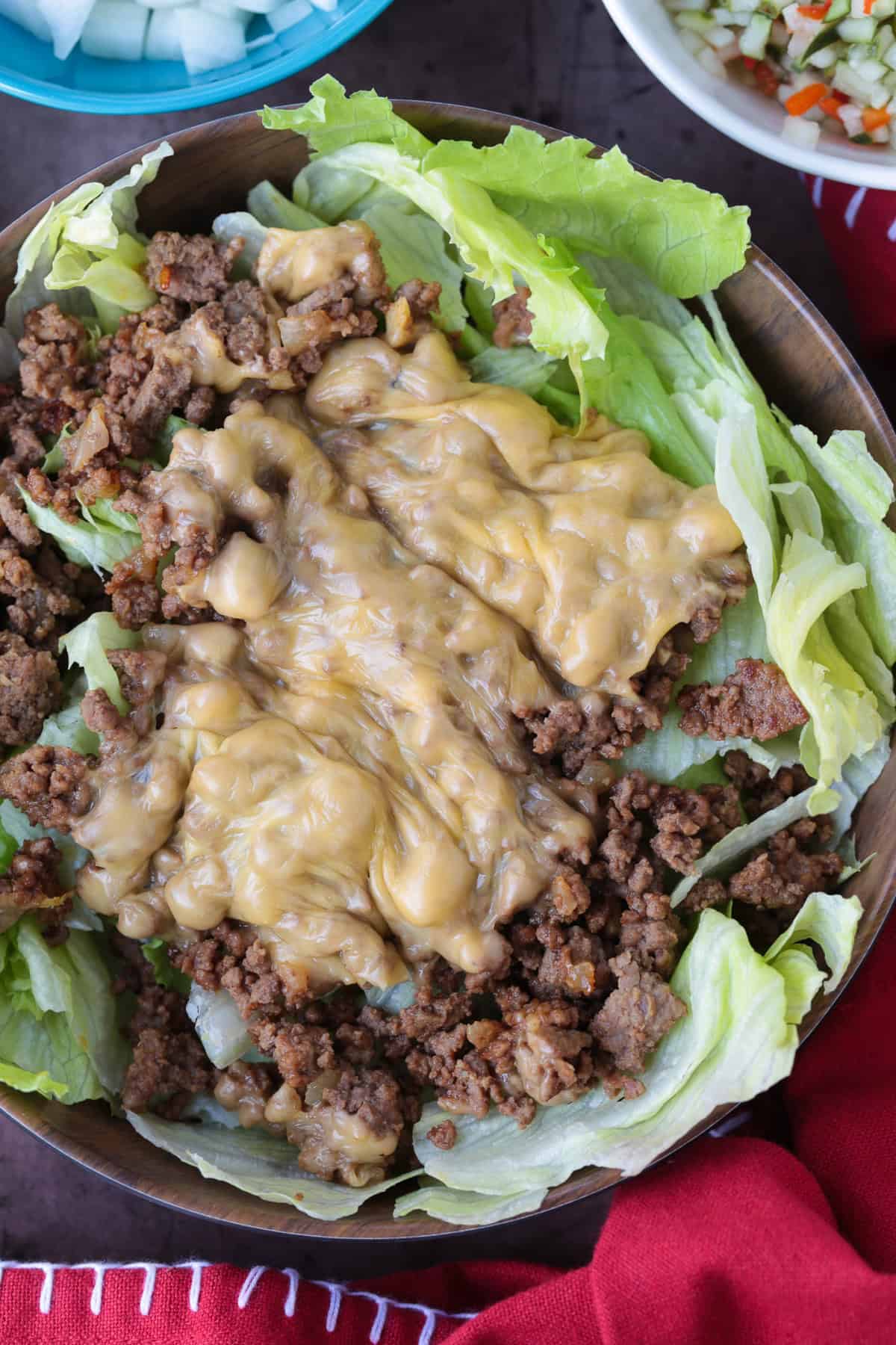 Make a Cheeseburger Bowl for parties, game days or just a fun dinner! All the flavors of your favorite cheeseburger drizzled with mac sauce! ground beef and melted cheese in a bowl with lettuce