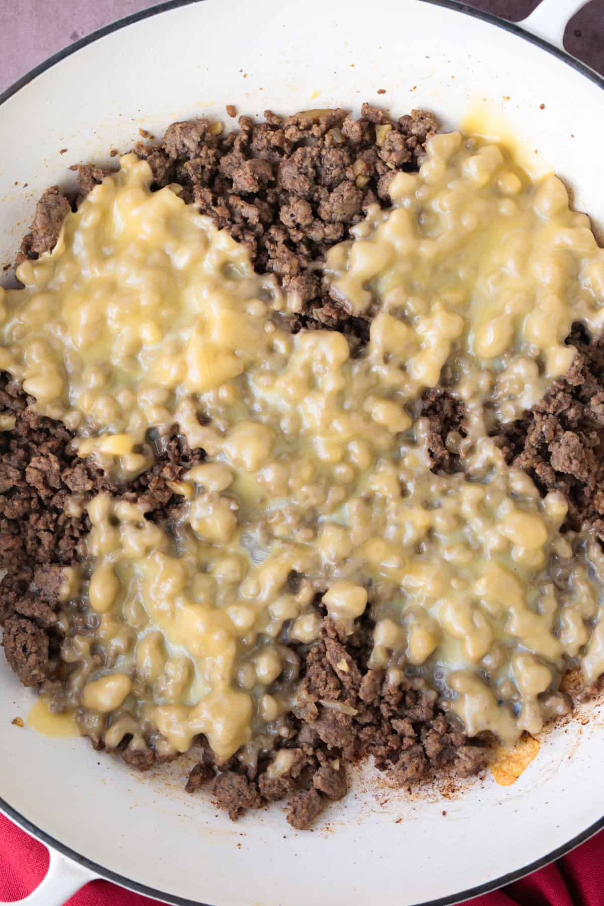 Make a Cheeseburger Bowl for parties, game days or just a fun dinner! All the flavors of your favorite cheeseburger drizzled with mac sauce! ground beef in a skillet with cheese melted on top