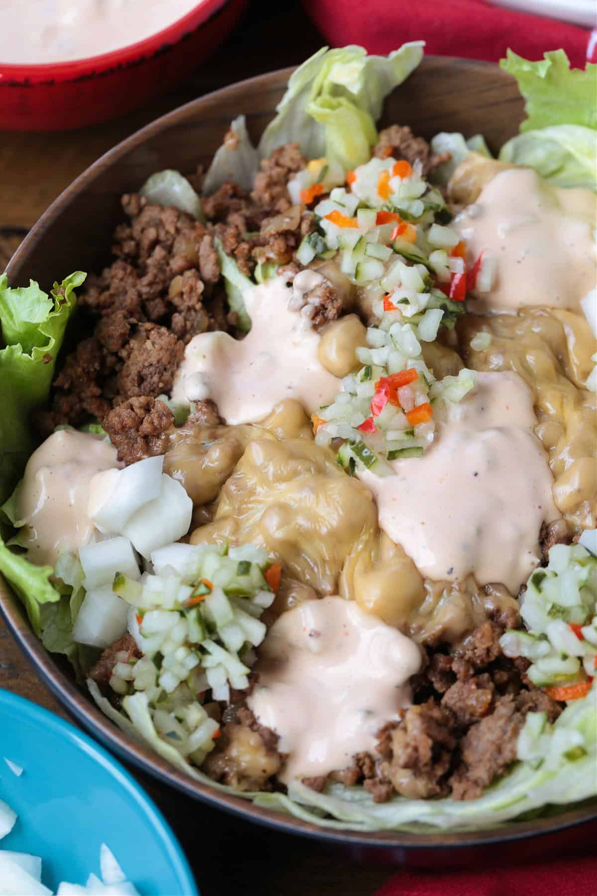 Make a Cheeseburger Bowl for parties, game days or just a fun dinner! All the flavors of your favorite cheeseburger drizzled with mac sauce! cheeseburger salad with sauce and pickle relish