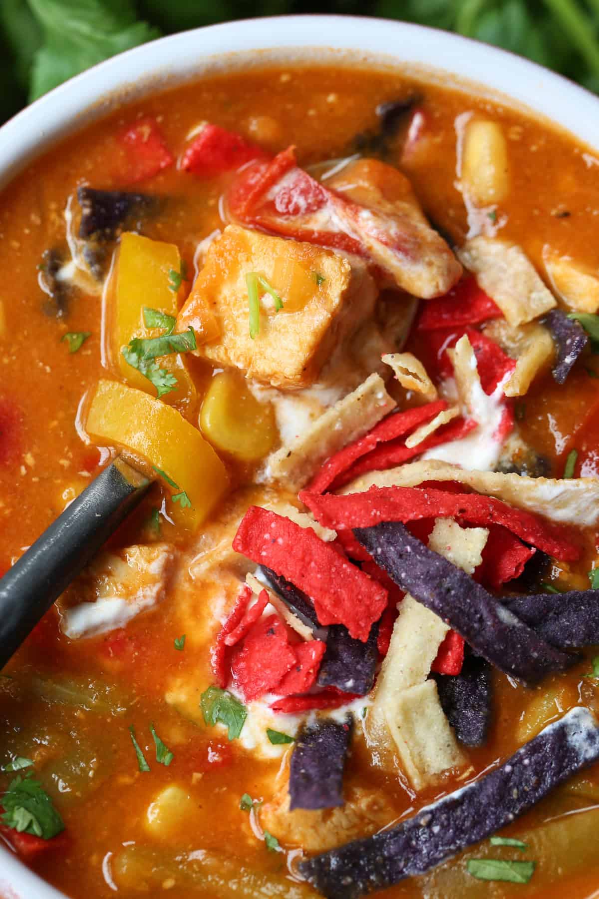 Our Chicken Fajita Soup is packed with protein! A secret ingredient makes this soup thick and creamy, without any cream or cream cheese! chicken fajita soup in a bowl with spoon