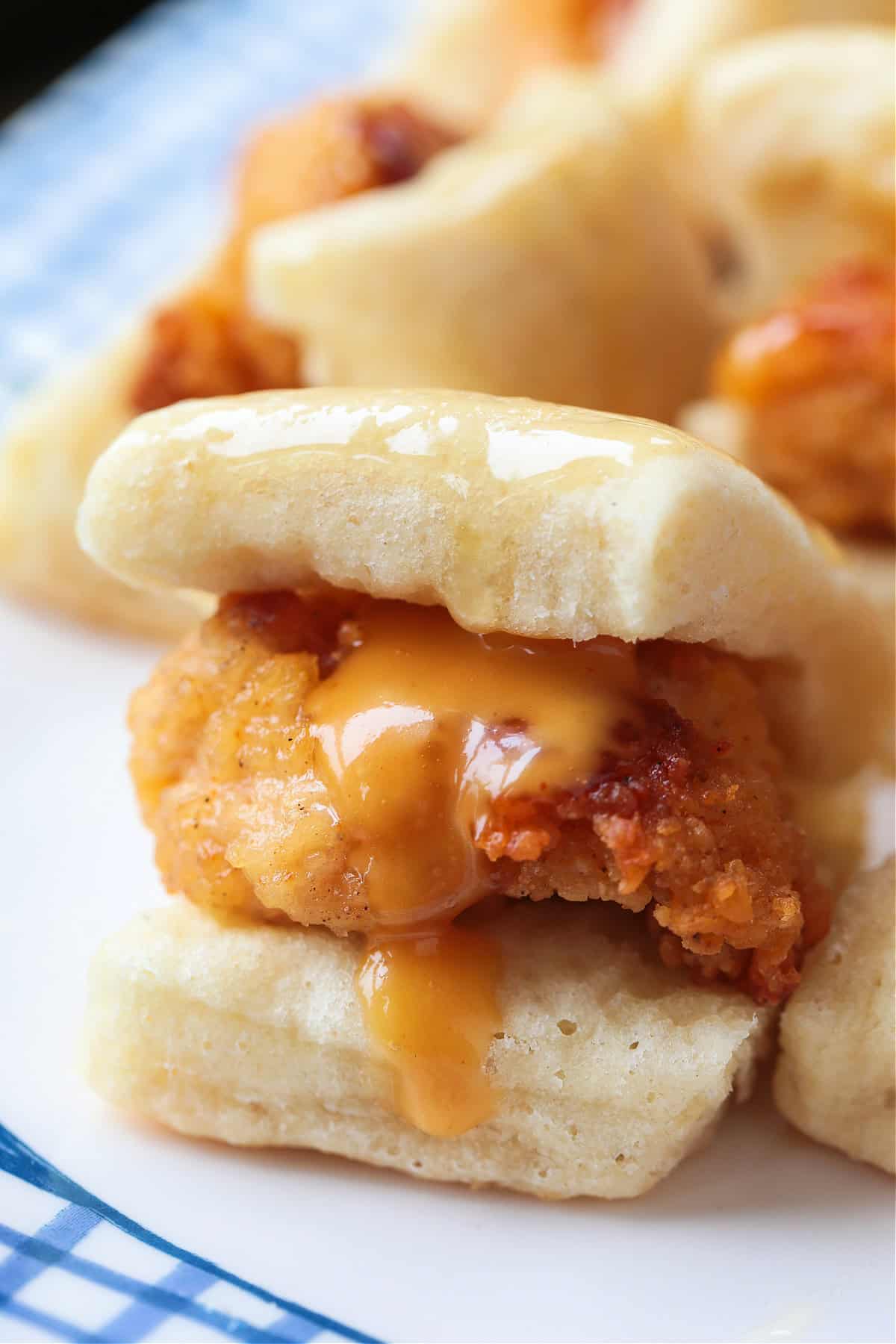 Make these Copycat Chicken Minis for your next party or game day! Just like the Chick Fil A version only better because they're homemade! close up of mini chicken sliders with sauce