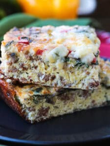slices of egg casserole with sausage stacked on black plate