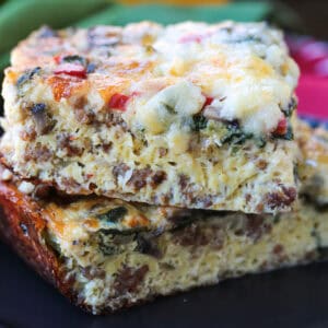 slices of egg casserole with sausage stacked on black plate