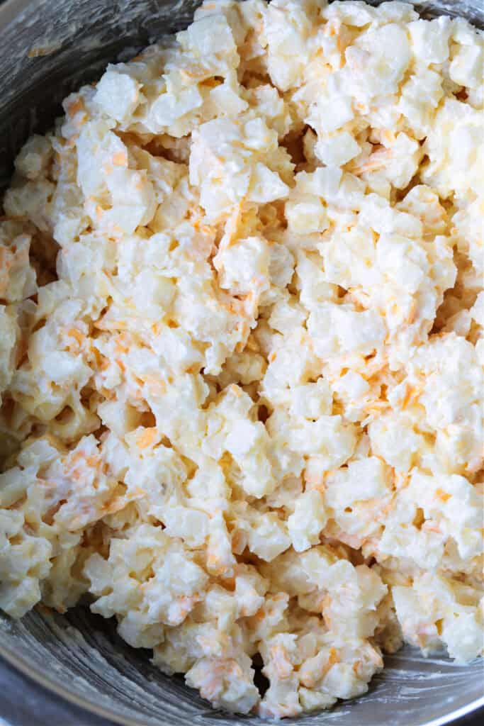 These cheesy, comforting Party Potatoes are always a hit! An easy, make ahead potato casserole that goes with just about any meal! makings for a potato casserole in a bowl