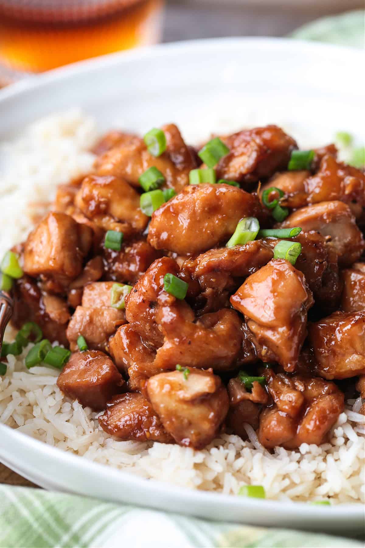 Our Easy Bourbon Chicken is a family favorite dinner recipe! Tender chicken in a sweet and tangy sauce with just a splash of bourbon. chicken in a bourbon sauce on a plate with rice