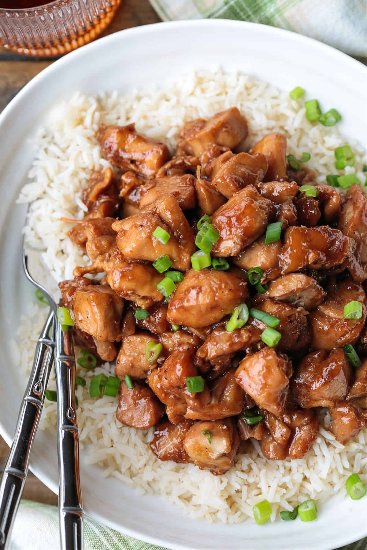 Our Easy Bourbon Chicken is a family favorite dinner recipe! Tender chicken in a sweet and tangy sauce with just a splash of bourbon. bourbon chicken with scallions over a bed of rice