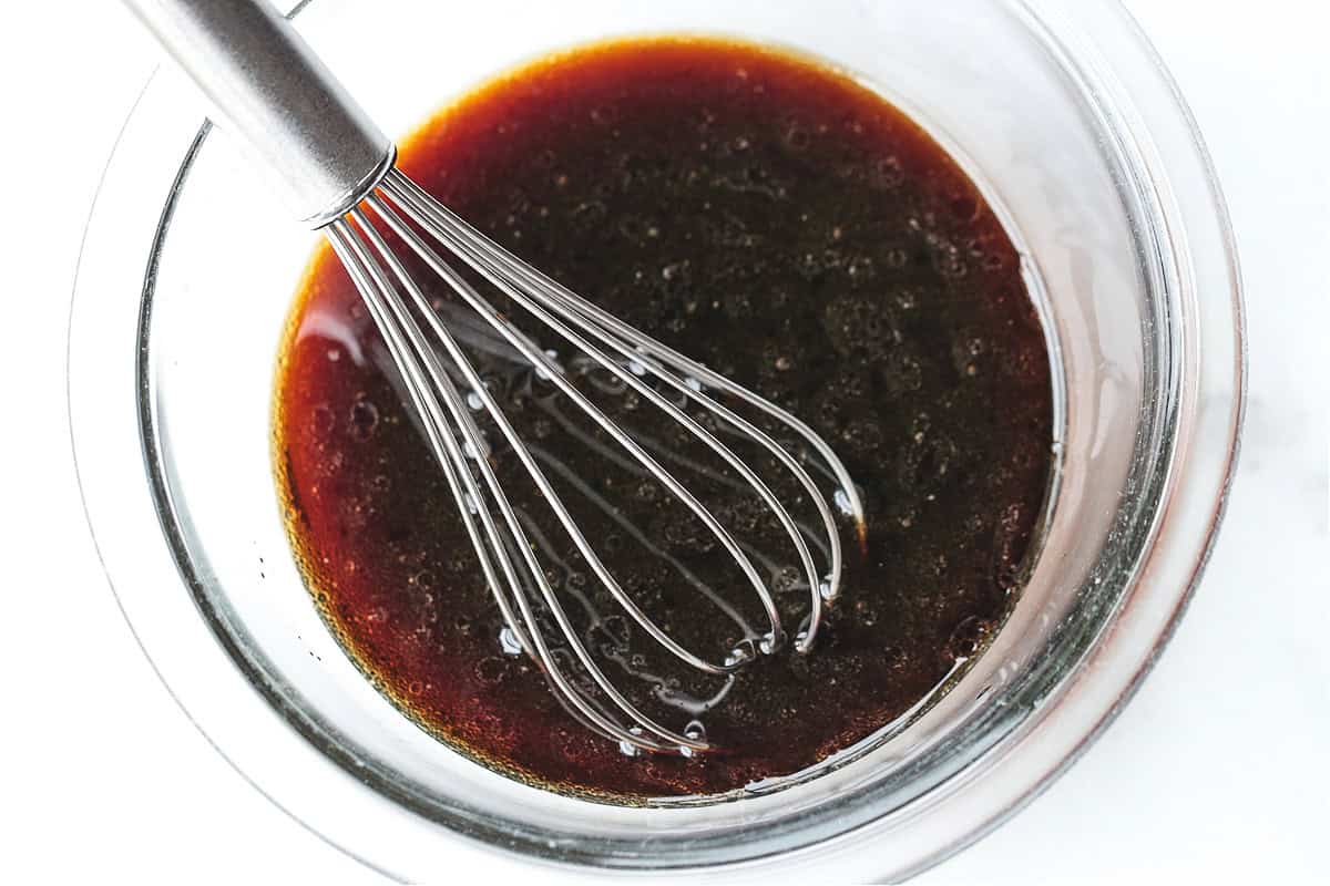 Our Easy Bourbon Chicken is a family favorite dinner recipe! Tender chicken in a sweet and tangy sauce with just a splash of bourbon. soy sauce mixture in a glass bowl with whisk