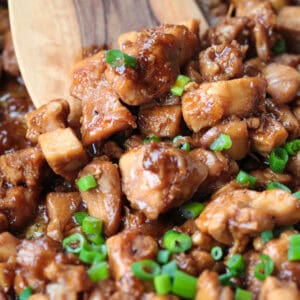 close up of bourbon chicken with wooden spatula