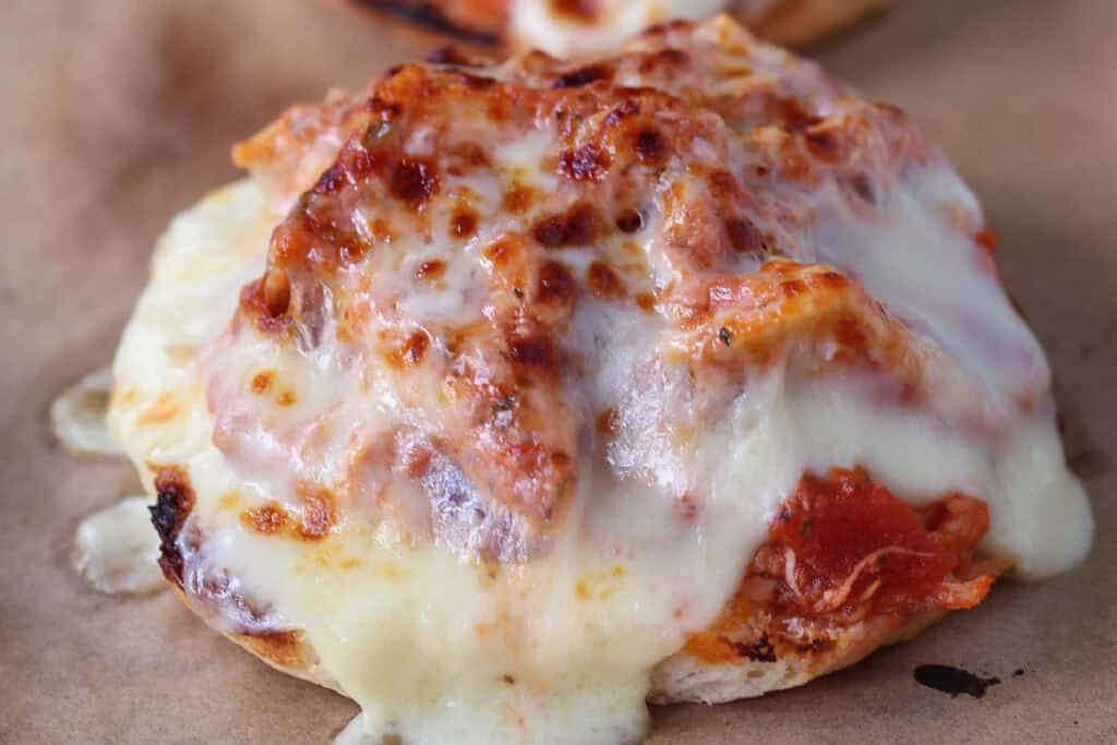 Slow Cooker Chicken Parmesan Sandwiches are an easy dinner for any night of the week! Perfect for meal prepping, game days or holidays! melted mozzarella cheese on a shredded chicken sandwich