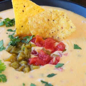 tortilla chips dipped into queso