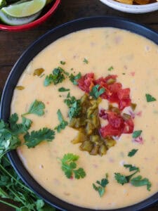 close up of a bowl with queso and toppings