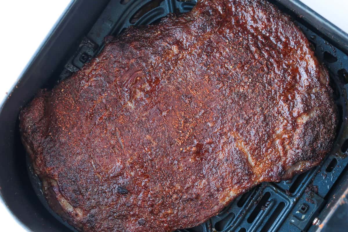 Need dinner fast? Our Air Fryer Flank Steak recipe delivers a tender, juicy, and flavorful steak with a crispy sear in just minutes! cooked flank steak with a seared crust