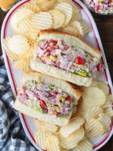 chopped italian subs on a platter with chips