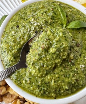 basil walnut pesto in a white bowl with spoon