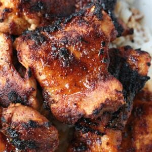 broiled chicken thighs on a plate with rice