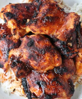 broiled chicken thighs with seasonings on plate with rice