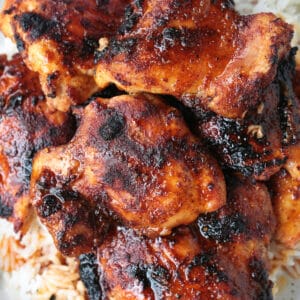 broiled chicken thighs with seasonings on plate with rice