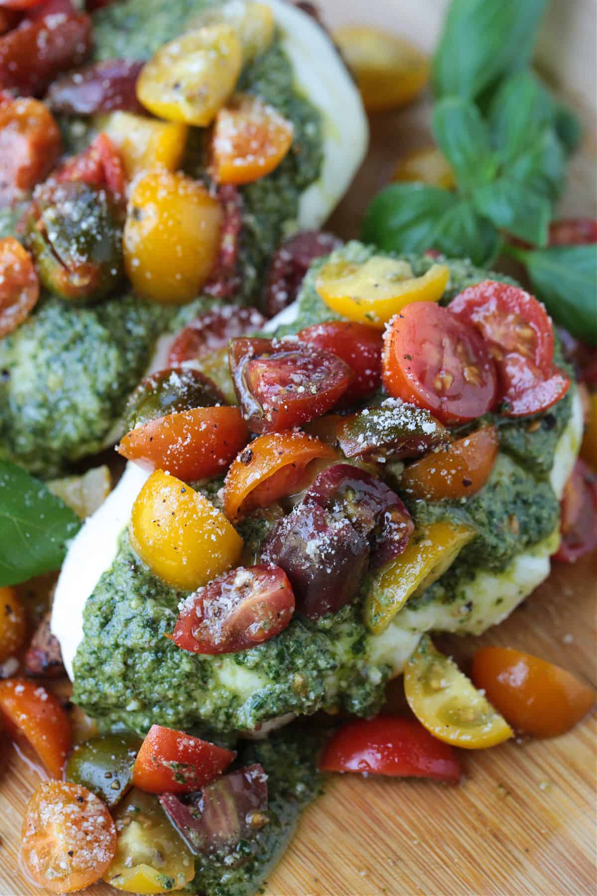 Grilled Chicken Margherita is an easy dinner recipe made with juicy grilled chicken, fresh mozzarella, ripe tomatoes, garlic, and pesto. chicken margherita on board with basil