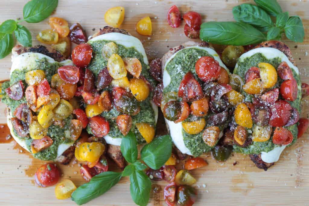 Grilled Chicken Margherita is an easy dinner recipe made with juicy grilled chicken, fresh mozzarella, ripe tomatoes, garlic, and pesto. chicken with mozzarella cheese, pesto and tomato topping