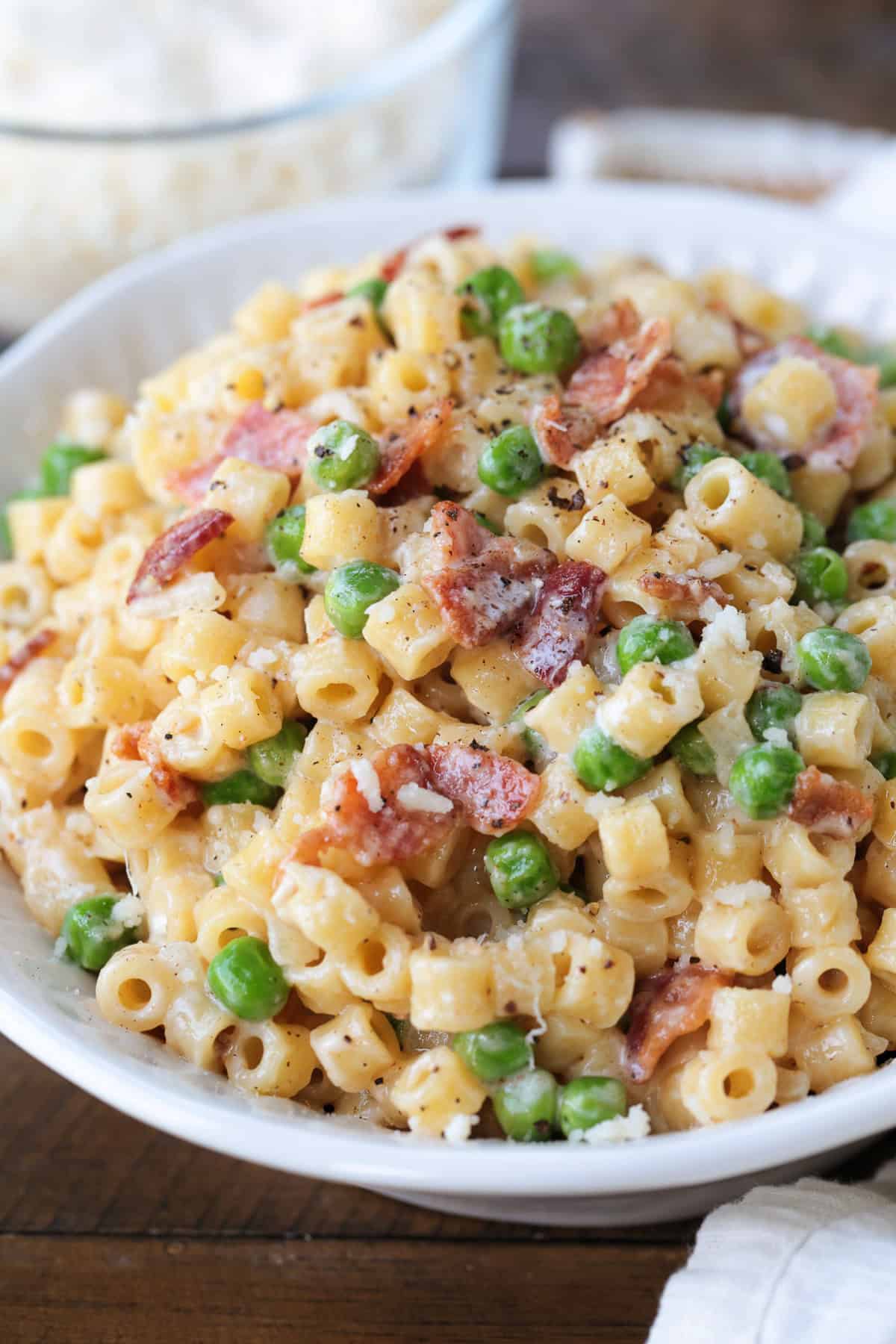 This creamy Bacon and Pea Ditalini pasta can be served as a side dish to dinner or as a meal on its own. Ready in 30 and sure to please! ditalini with bacon and peas in bowl from the side