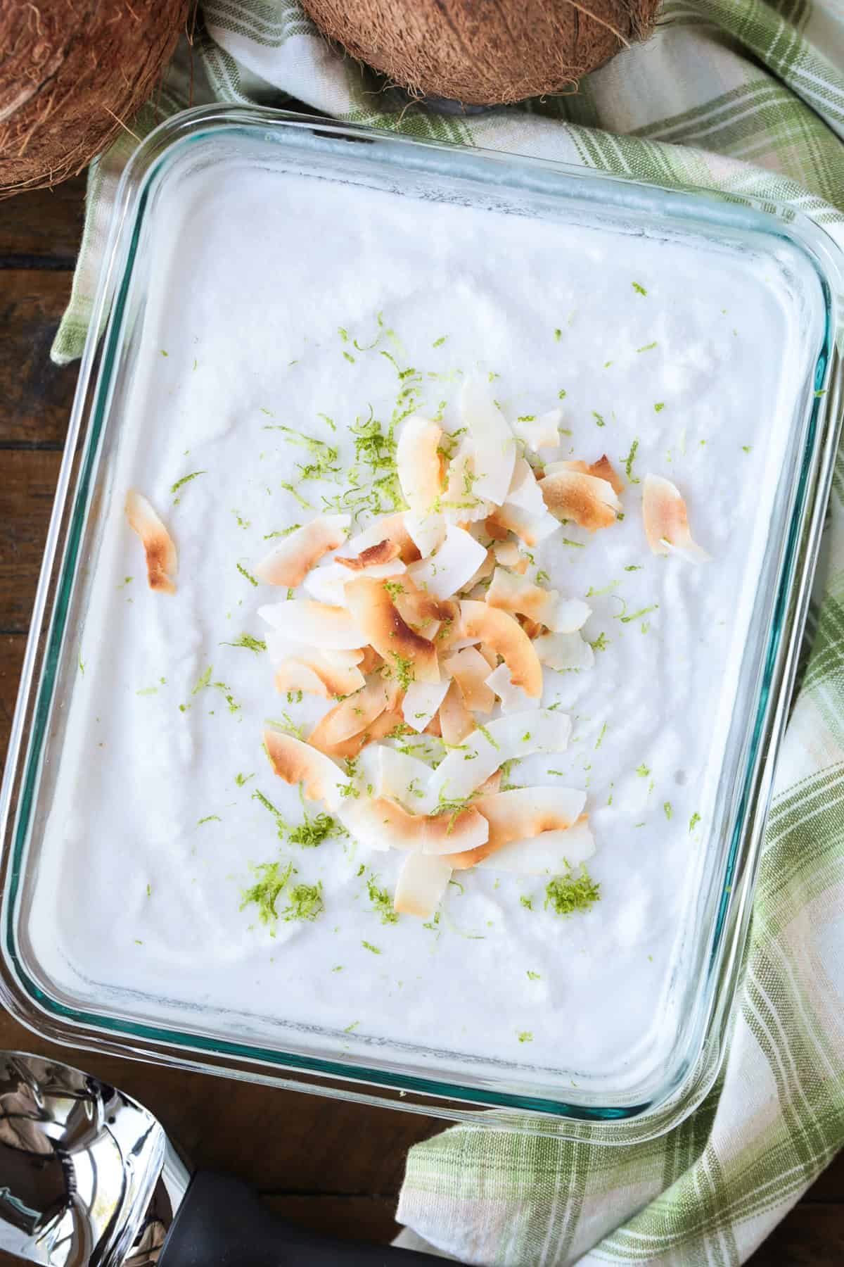 This homemade coconut sorbet is bursting with tropical flavor! Made with coconut milk and simple ingredients for a refreshing summer dessert. coconut sorbet in glass dish topped with toasted coconut