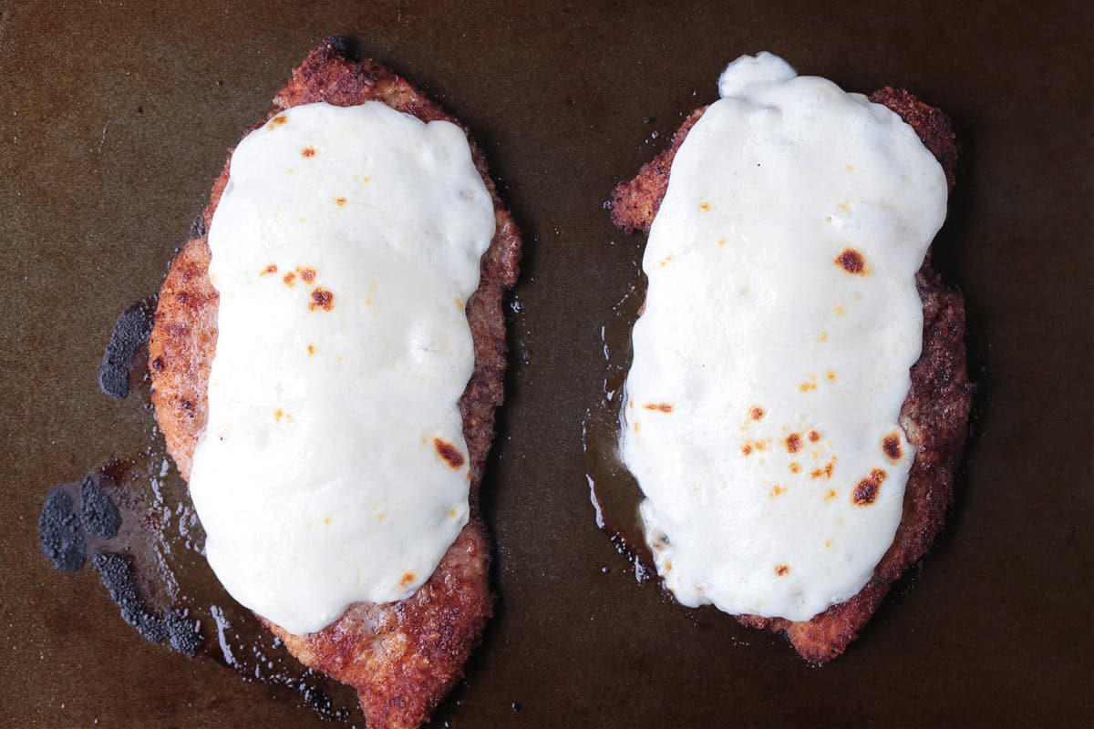 Super crispy chicken parmesan, not made soggy form baking in sauce. Serve over pasta or on a plate with marinara for the ultimate crispiness! chicken cutlets with melted mozzarella cheese on top