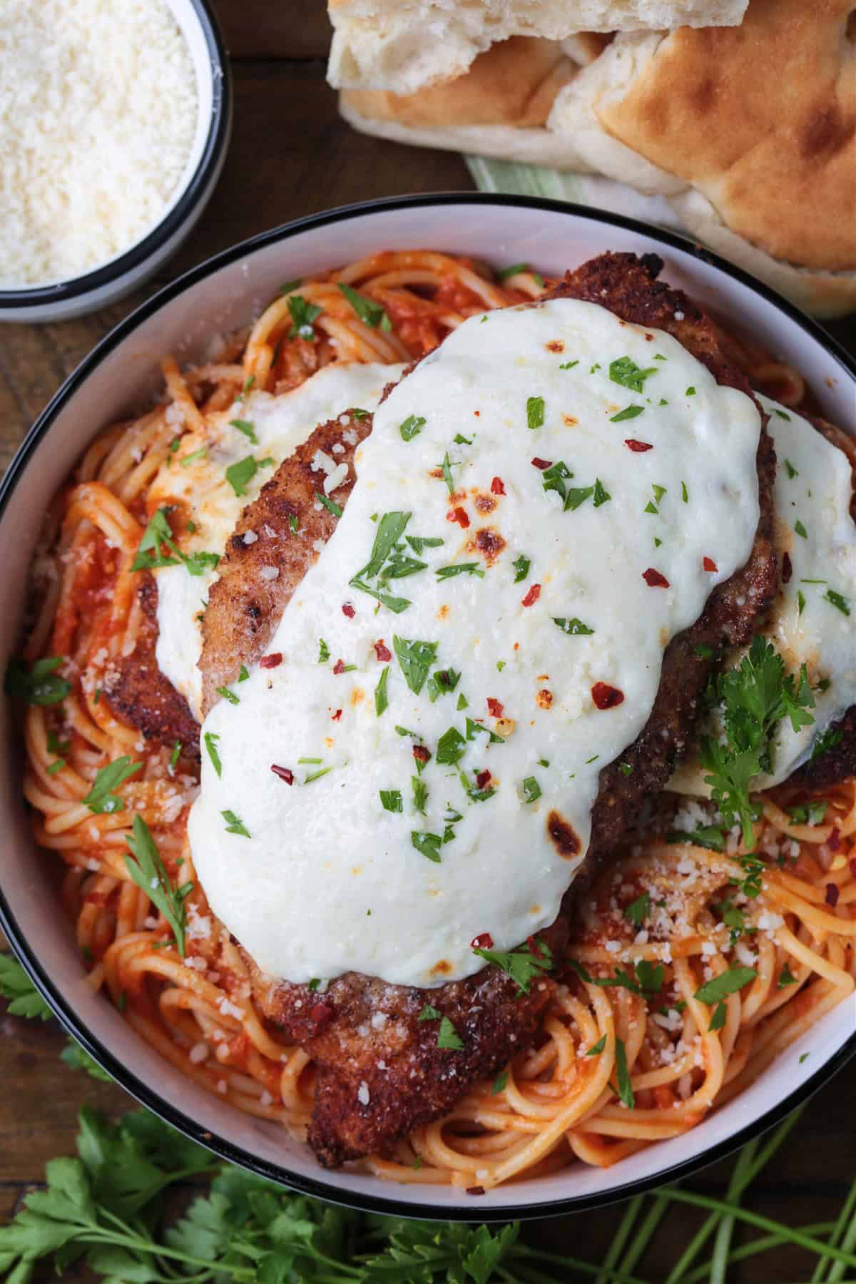 Super crispy chicken parmesan, not made soggy form baking in sauce. Serve over pasta or on a plate with marinara for the ultimate crispiness! chicken parmesan on a bed of spaghetti