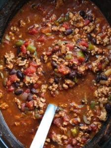turkey chili in a slow cooker with ladle
