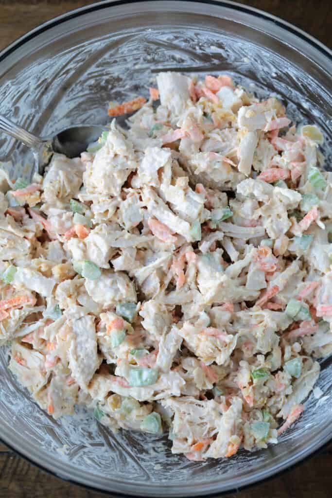 Chickpea Chicken Salad is made with tender chicken, crunchy veggies and buttery chickpeas. A protein packed meal that's ready in minutes! chicken salad in a glass bowl being mixed together