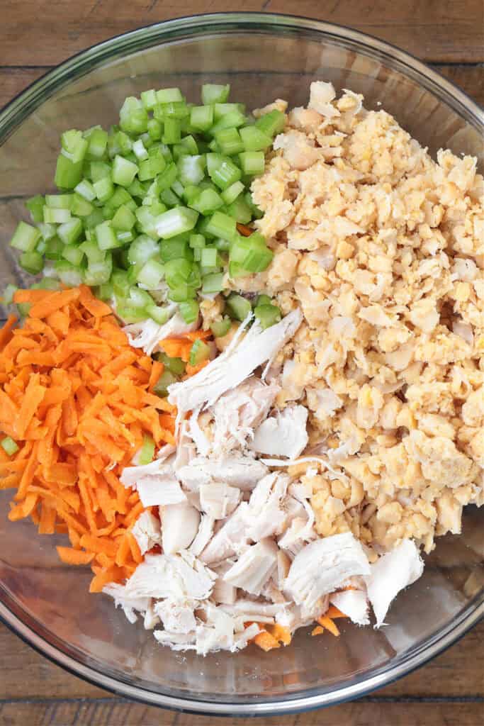 Chickpea Chicken Salad is made with tender chicken, crunchy veggies and buttery chickpeas. A protein packed meal that's ready in minutes! ingredients in a bowl for making chickpea chicken salad