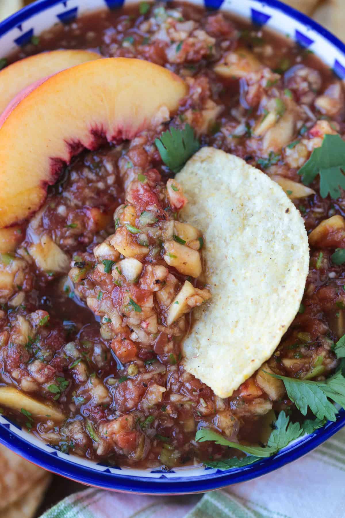 tortilla chip dipping into bowl os salsa