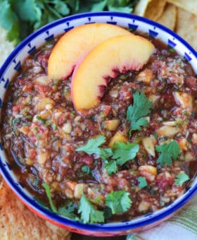 peach mango salsa in a bowl with peach slices on the side