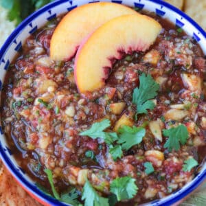 peach mango salsa in a bowl with peach slices on the side