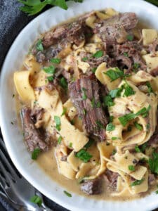 shredded beef and noodles in a bowl with gravy