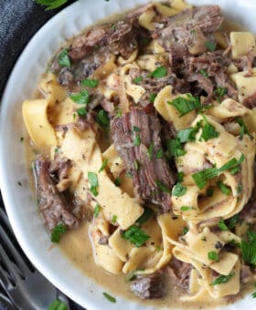 shredded beef and noodles in a bowl with gravy